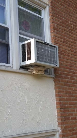 a window unit shimmed by books 